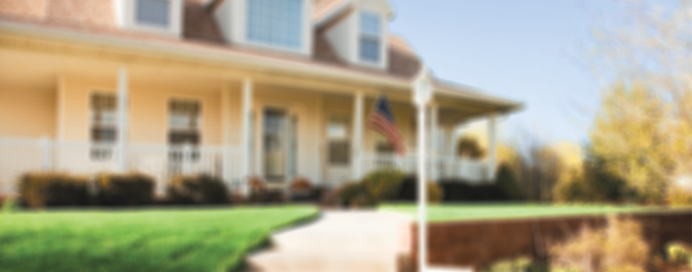 Graphite-toned sketch of a large house exterior with a porch, lawn, and flag pole under an open sky